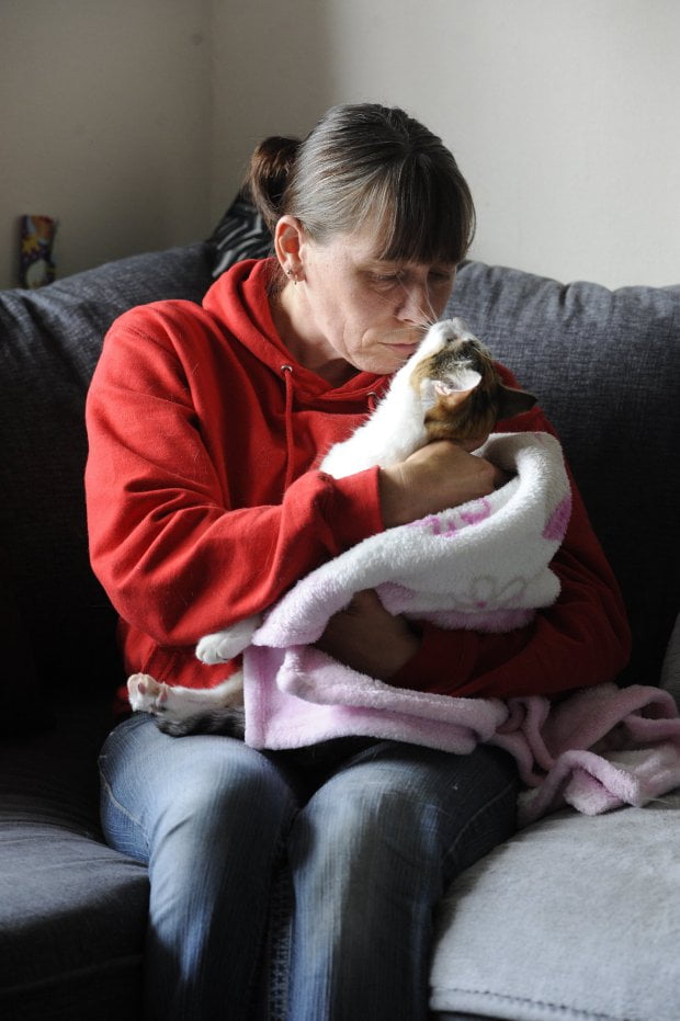 Kim Breckon with her rescued cat Carrie, who she massaged back to health from paralysis.