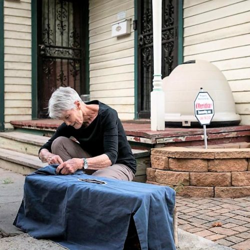 Barb Jones places a blanket over a cage containing a female feral cat to keep her calm
