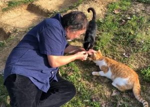 Ai Weiwei with 2 of his 3 cats. These 2 are Shadow a black cat and Yellow the ginger tabby and white. The 3rd is Half